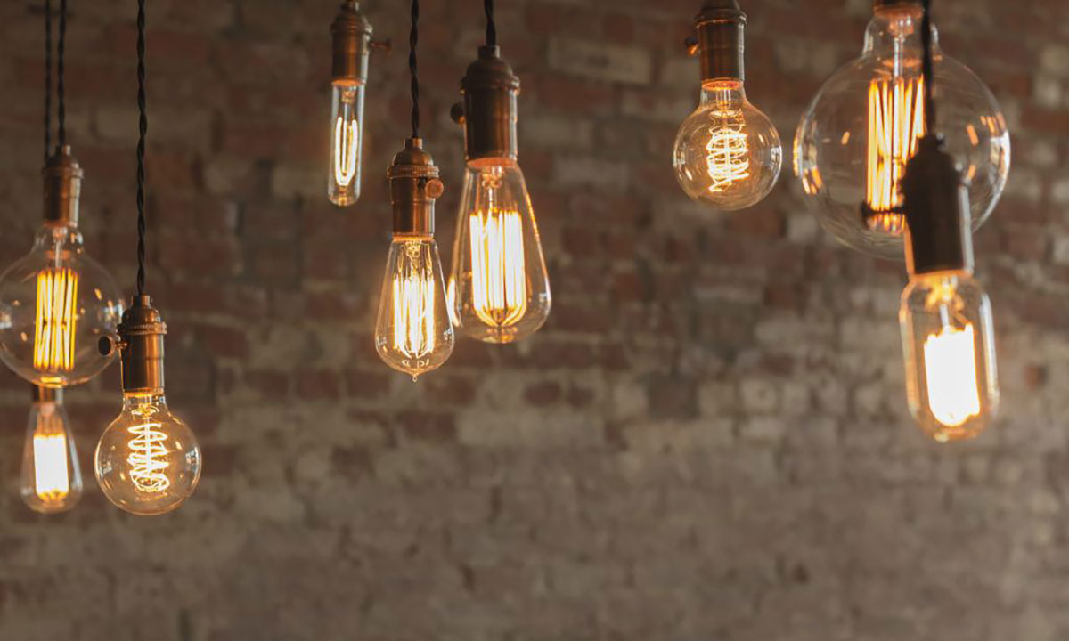 Lit Edison bulbs of different shapes with a brick wall background | Dawson Electric