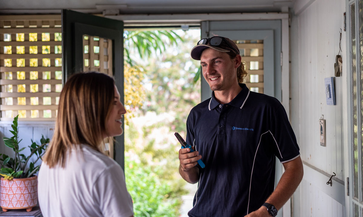 Electrician talking to a customer in her hallway | Dawson Electric